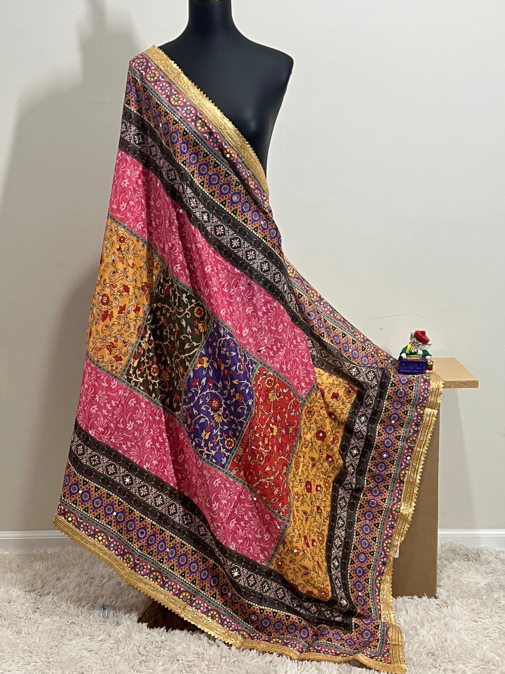 Malai silk dupatta with colorful patchwork and gold border, draped on mannequin