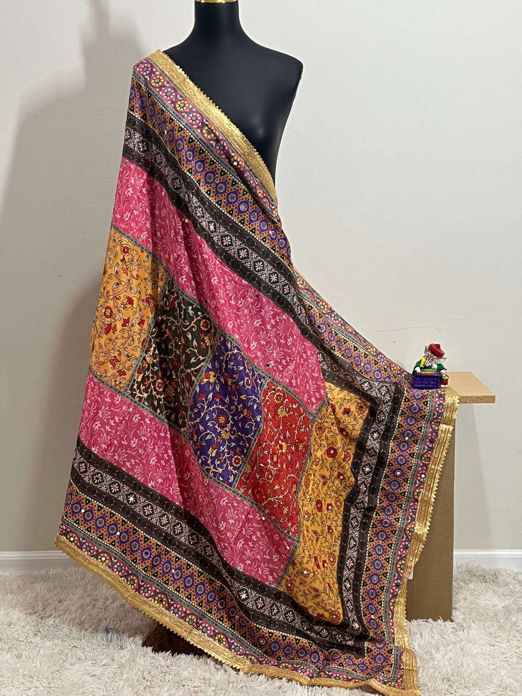 Malai silk dupatta in vibrant patchwork with a gold border, draped over a mannequin.