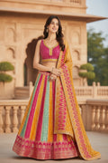 House Of Indian Wedding Attire Banarasi lehenga choli set in pink, yellow, and teal with intricate woven patterns. Model wears a sleeveless blouse and flowing skirt.