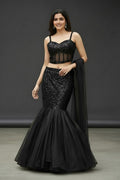 House Of Indian Wedding Attire black shimmer lehenga with corset blouse and flared tulle skirt. Model wears a strappy, sweetheart neckline top.