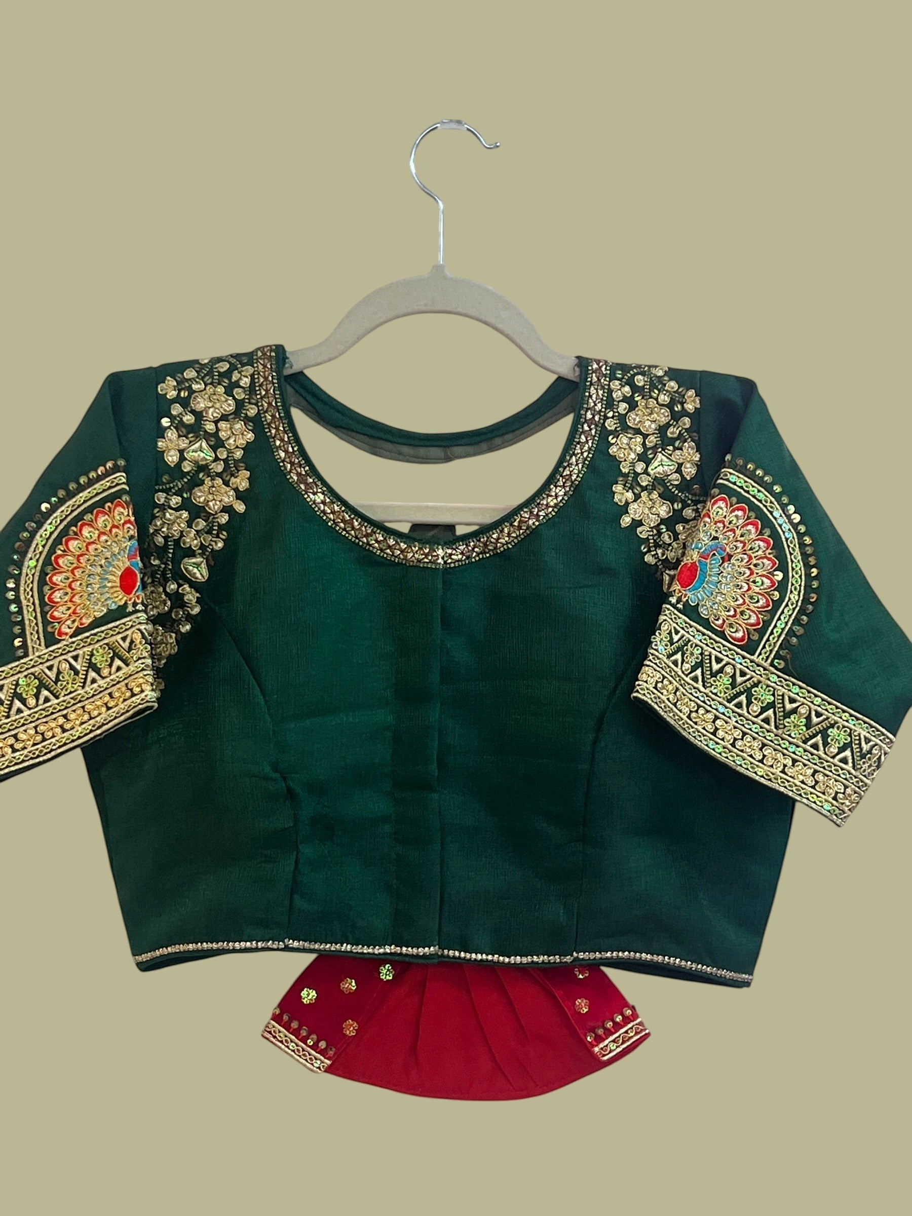 House Of Indian Wedding Attire deep green silk wedding blouse with gold embroidery, sequins, and colorful peacock motifs on sleeves.
