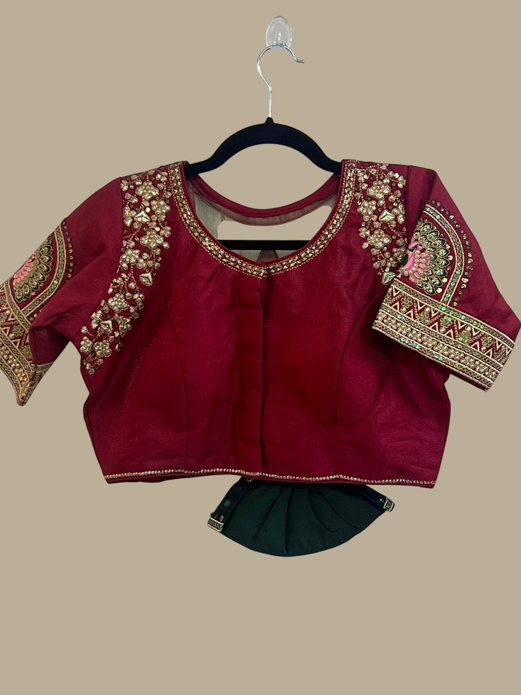 House Of Indian Wedding Attire maroon silk-like blouse with gold embroidery and matching dark green skirt.