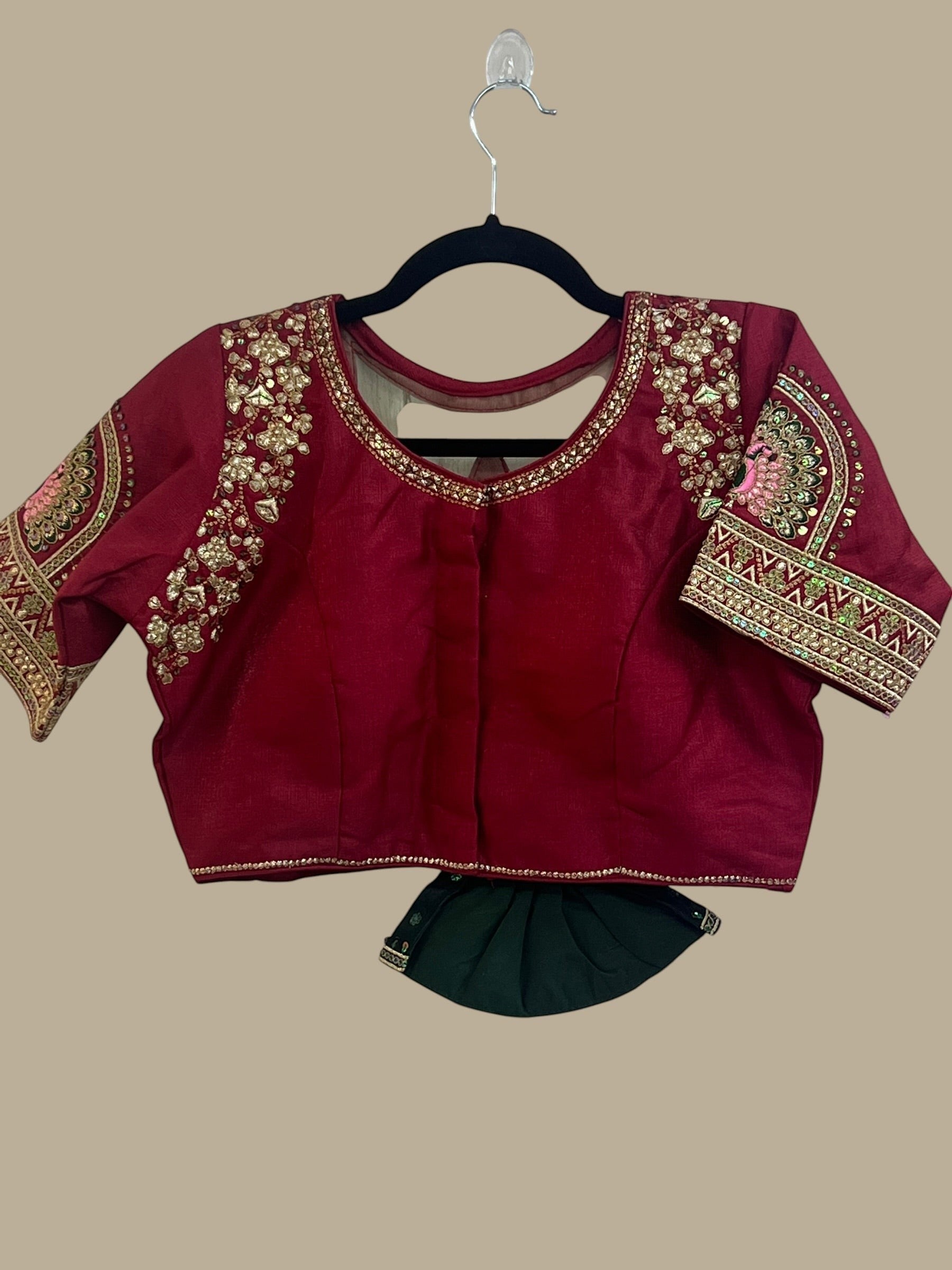 House Of Indian Wedding Attire maroon silk-like blouse with gold embroidery and matching dark green skirt.